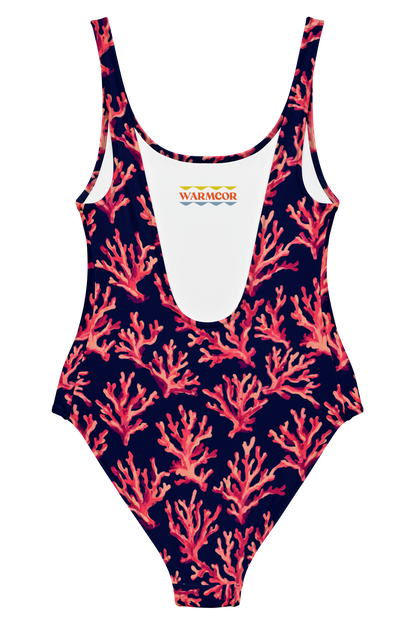 A one-piece swimsuit with a dark navy blue background and a coral pattern in shades of pink and red. The swimsuit features a white scoop neckline and a small 'WARMCOR' logo printed on the chest.